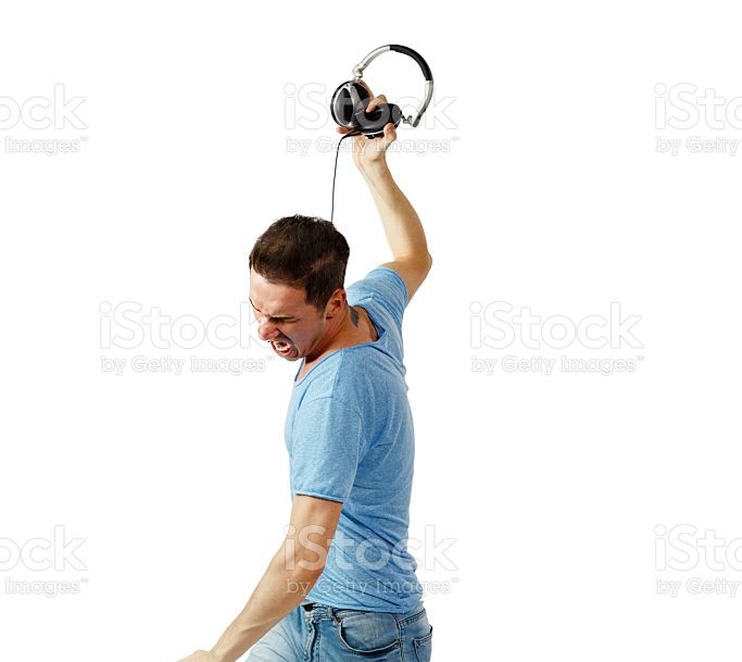 Angry male with blue jeans and shirt throwing headphones